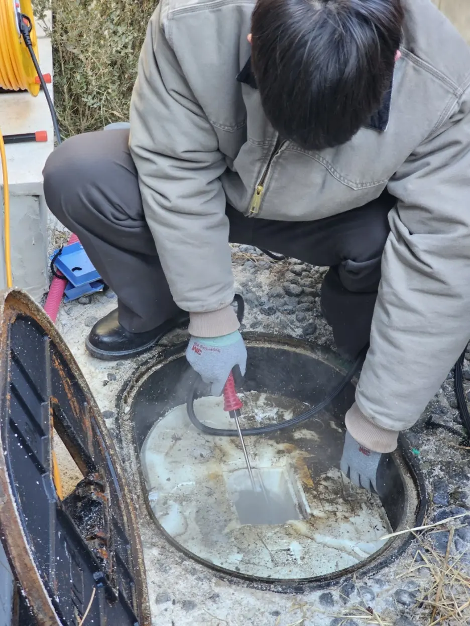 공실 건물에서 동결된 수도계량기를 해빙 장비로 점검하는 모습