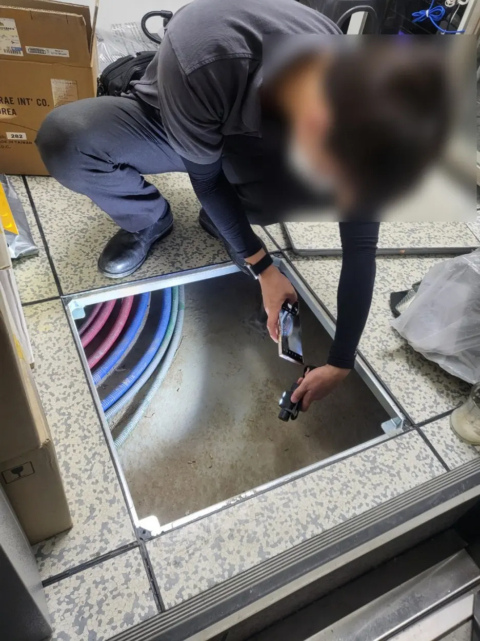 바닥 점검구 안 배관을 촬영하며 누수 원인을 확인하는 현장